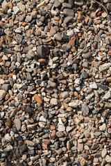 Pebble texture. The surface of the earth with small multi-colored stones. Natural background. Ground texture.