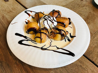 Dish of Banana Fritters with Vanilla Sauce in Thailand.