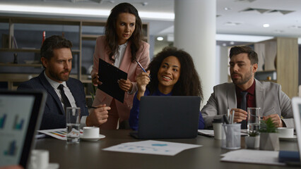 Obraz premium Business team sharing ideas researching laptop computer in office building.