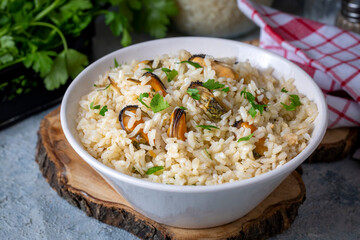 Mussel rice pilaf. Rice with mussels on small white plate on ceramic.