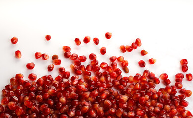 Close-up red pomegranate seeds on white background. Fresh juicy pomegranate seeds isolated on white., top view, selective focus, copy space