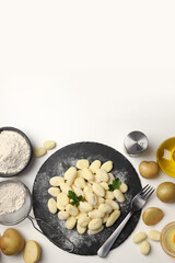 Concept of cooking with raw potato gnocchi, space for text