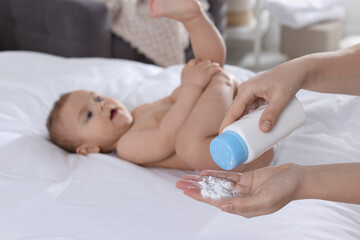 Obraz na płótnie Canvas Mother with dusting powder near her baby at home, closeup