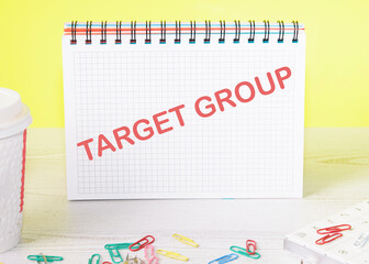 target group text on a notebook standing on a table on a yellow background