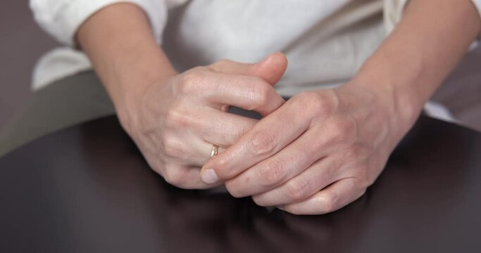Troubled marriage. A woman has a troubled marriage and want to takes off her golden ring from the finger in the room.