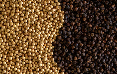White pepper and black pepper close-up as a background. Spices of Cambodia. Seasoning for dishes. Additive ingredient for the preparation of delicious delicacies. Sauce set