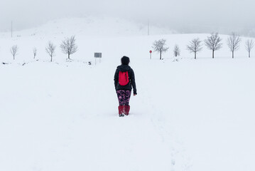 Fototapeta na wymiar Female hiker walking in the snow