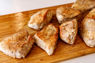 Fried turkey fillet on a wooden tray.