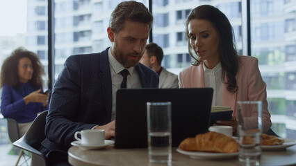 Serious ceo team working sharing business ideas research laptop computer in cafe