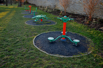 outdoor gym in the yard with a stone sandstone wall and a flexible circle-shaped rubber floor....