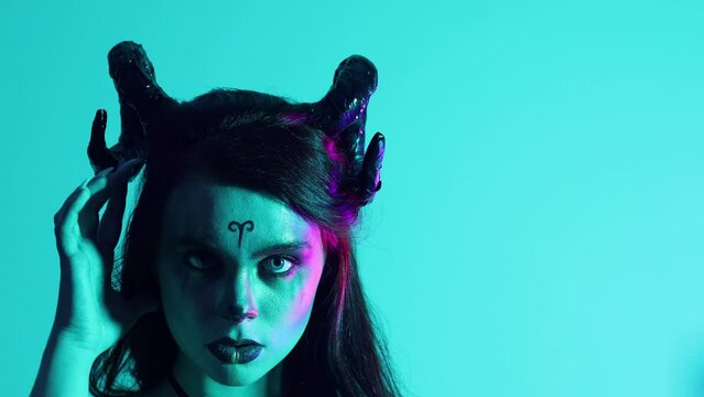 Evil woman with makeup zodiac signs of Capricorn or Aries or Taurus or demon devil. Girl with horns on her head.