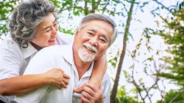 relationship elderly couple health care in park, retirement old adult man and woman embracing in love hug and smile, People retirement lifestyle concept.