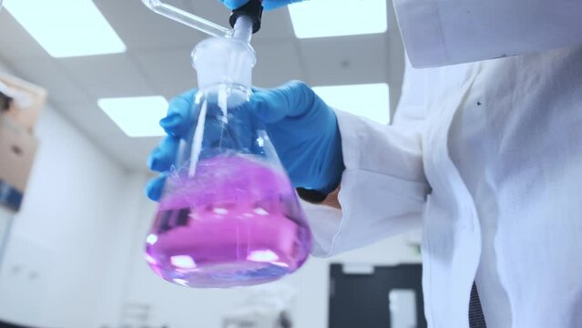 Scientists titrating samples to determine the exact concentration of the solution in analytical laboratory. Water analysis in the moder laboratory. 