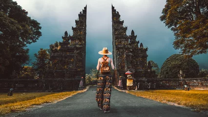 Abwaschbare Fototapete Tourist woman with backpack at vacation walking through the Hindu temple in Bali in Indonesia © Davide Angelini