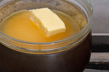 Bain-marie with sugar, butter and honey on saucepan