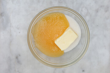 Top view of sugar, butter and honey in glass bowl