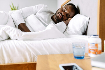 Black man sleeping while lying in bed at home