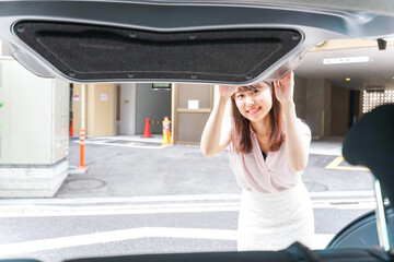 車のトランクを開ける女性