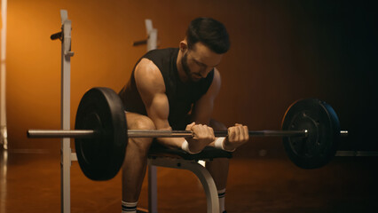 Fototapeta na wymiar Athletic sportsman working out with barbell on dark background