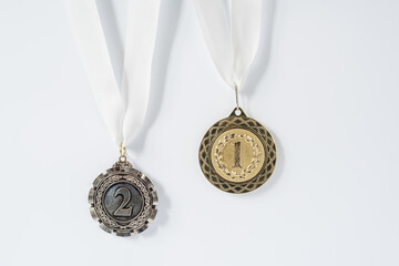 First and second place - gold and silver medal on a white background.