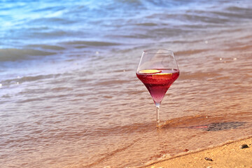 Wine glass with a cocktail by the sea.