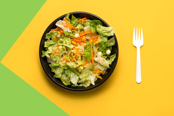 Lettuce salad with carrot,corn and cheese and white fork .Healthy food concept