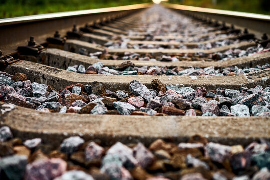 Railway track line going into distance, railroad train track with crushed stone, two parallel rails