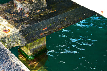 Fototapeta na wymiar Abandoned pier. Corrosion of reinforced concrete.