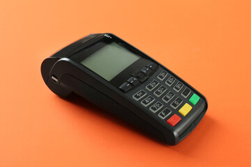 New modern payment terminal on orange background