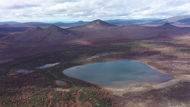 Aerial drone video Autumn landscape in the tundra. Mountains, volcanoes, lakes, colored yellow leaves, bright colors