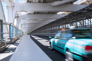 Motion blurred taxi on Rainbow Bridge in Tokyo,...