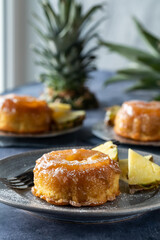 Pineapple upside down cakes with caramel sauce beside a sunny window.