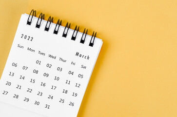 March 2022 desk calendar on light yellow background.