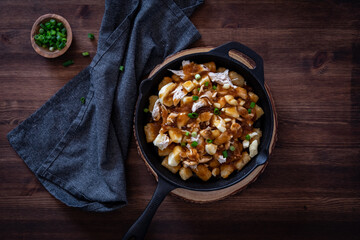 Top down view of a skillet of tater tot poutine, fresh out of the oven.