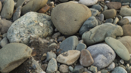 Large and small stones on the bank of the mountain river, background