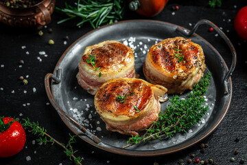 Premium Beef Steak. portion of juicy beef tenderloin steak covered bacon on dark concrete background with spices. Ketogenic diet food, top view