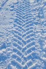 Tractor tread pattern in close up on snowy winter road: