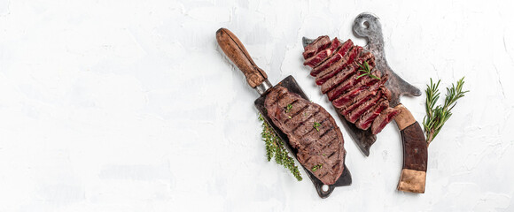 Piece of cooked rump steak from marble beef medium rare served on old meat butcher. Long banner...