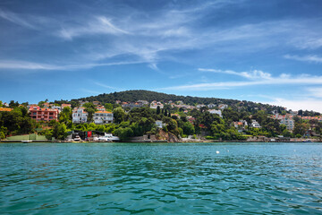 View of the sea and the coast of the island with residential buildings. Travel to Buyukada, Adalar, Prince Islands, Istanbul, Turkey