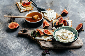 Crostini with ricotta cheese, figs and honey on white background. Italian recipe menu