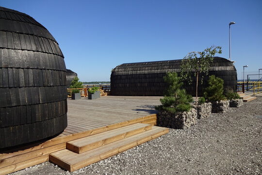 Igloo or iglu saunas. Gravel ground in the front in Port of Noblessner in Seaplane Harbor (Lennusadam in Estonian). Wooden deck and steps. Blue sky on a sunny summer day. Tallinn, Estonia, EU