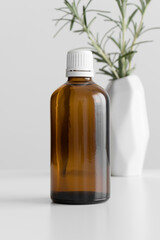 Pharmaceutical bottle mockup with a rosemary on the white table.