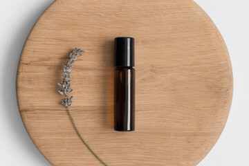 Amber glass roll-on bottle mockup lavender on the wooden background.