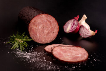 Krakowska, zywiecka sausage in a composition on a black background, blackboard. Polish cold cuts,...