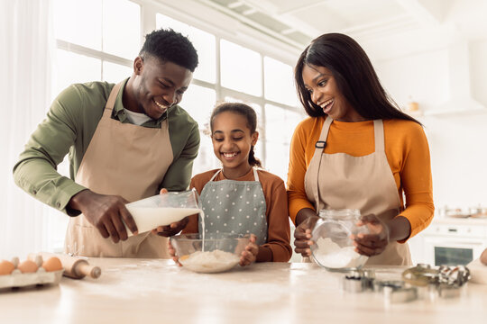 African Family Baking Pastry Adding Milk To Dough In Kitchen