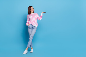 Photo of charming pretty woman wear striped sweater holding arm empty space isolated blue color background