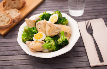 healthy appetizer of chicken pieces with broccoli and quail eggs in bowl for healthy lunch