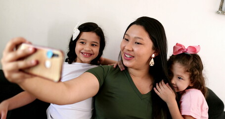 Fototapeta premium Mother holding cellphone taking photo selfie
