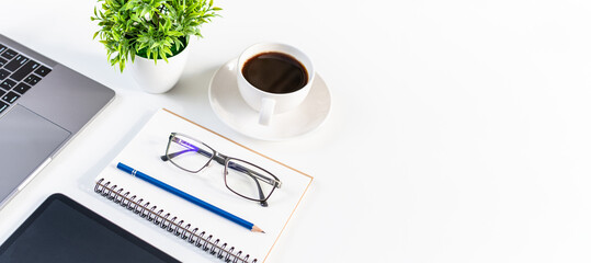 Laptop, coffee cup, tablet, and vase on white table in an office. Concept automation office using...