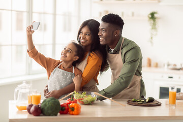 African Family Cooking And Making Selfie On Smartphone In Kitchen